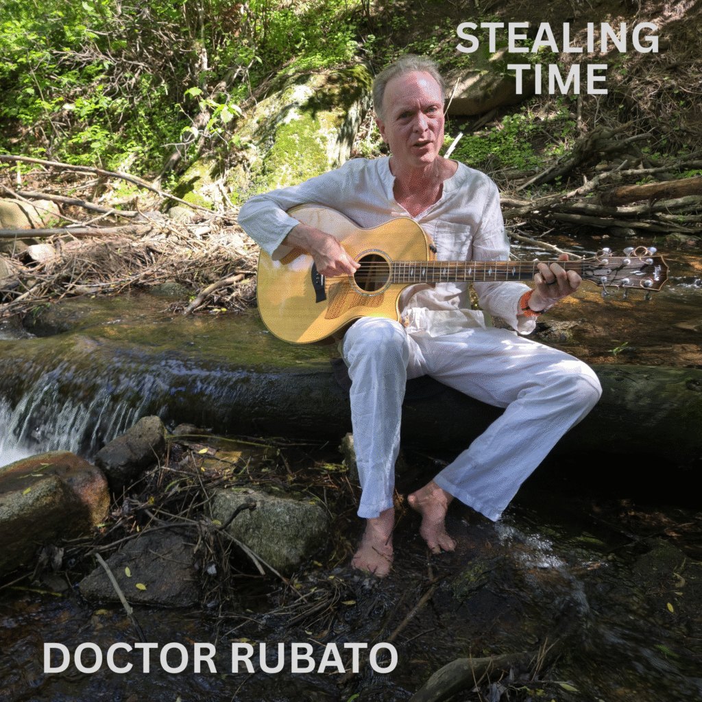 Stealing Time Cover Cover art for the album "Stealing Time" by Doctor Rubato. Doctor Rubato is dressed in white, playing his Taylor acoustic guitar, and appears to be singing. He is sitting on a log in the middle of a creek. The water is coming from behind him on his left and cascading down the log he is sitting on, to his right. His bare feet are in the water, along with some rocks and twigs. Behind him is a hillside with mossy boulders, bushes, and fallen branches. The area behind him is partially in the sun and partially shaded.