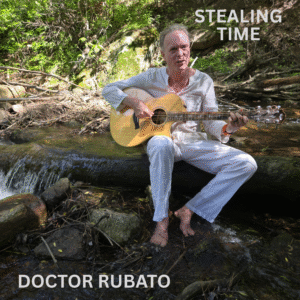 Cover art for the album "Stealing Time" by Doctor Rubato. Doctor Rubato is dressed in white, playing his Taylor acoustic guitar, and appears to be singing. He is sitting on a log in the middle of a creek. The water is coming from behind him on his left and cascading down the log he is sitting on, to his right. His bare feet are in the water, along with some rocks and twigs. Behind him is a hillside with mossy boulders, bushes, and fallen branches. The area behind him is partially in the sun and partially shaded.